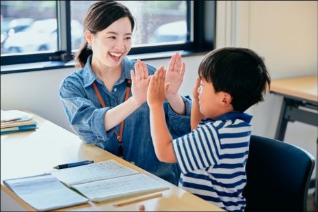 取り組んだことを一緒に喜び、ハイタッチする親子