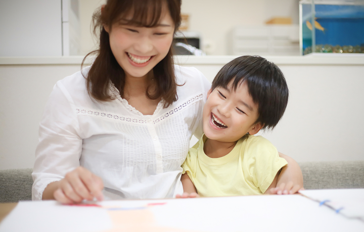 子どもが描いた絵を見ながら楽しそうに会話をする親子